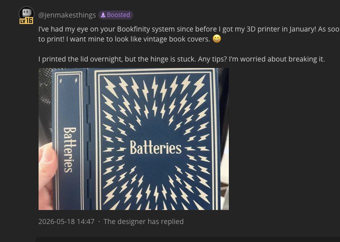 Screenshot of a fediverse post from @jenmakesthings about the Bookfinity system, showing a navy 'Batteries' book done up like an antique embossed hardback; the poster says they printed the lid overnight but the hinge is stuck, and a note shows the designer has replied.